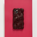 Burgundy Coconut Lane 3D Bubble phone case on a phone, set against a bright red background.