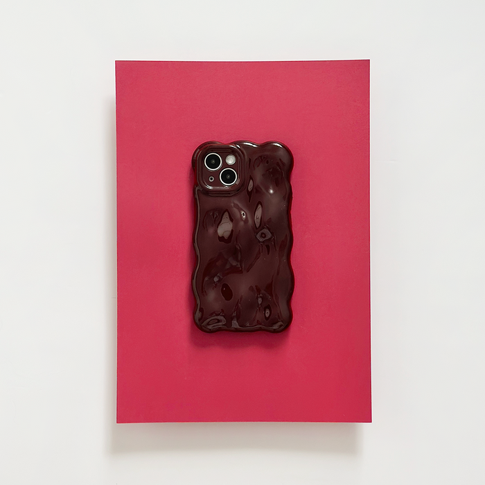 Burgundy Coconut Lane 3D bubble phone case on a phone, displayed on a red surface with a white background.