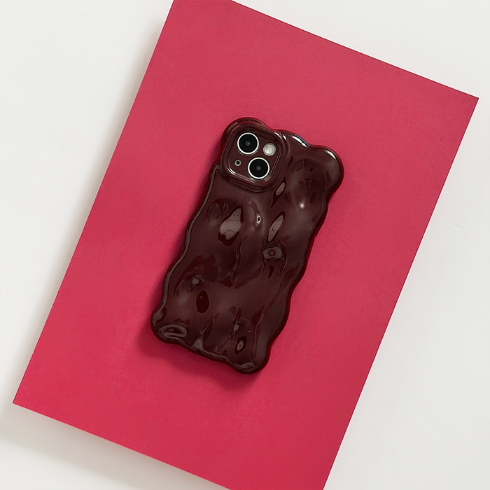 Burgundy 3D bubble phone case by Coconut Lane displayed on pink paper over a white background.