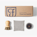 Field Company Cast Iron Care Kit box above the wood scrub brush, chain mail scrubber, and seasoning oil tin