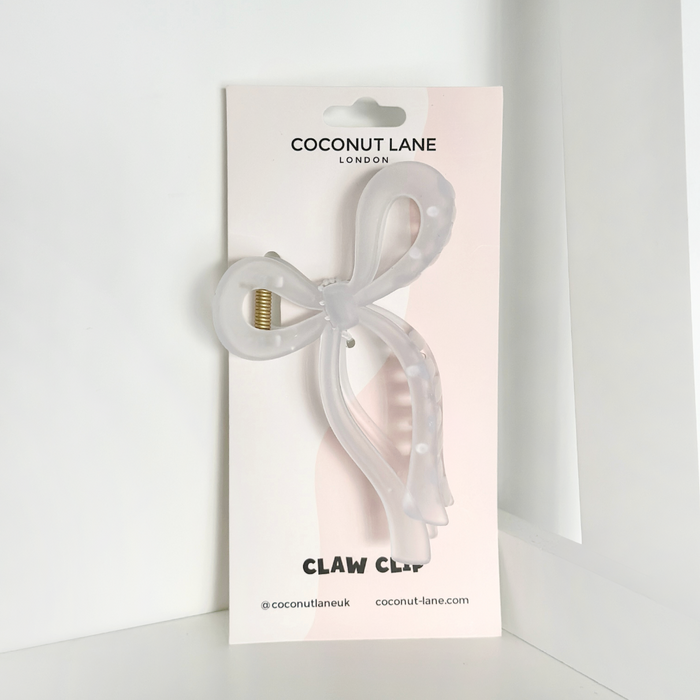 White bow-shaped claw clip on Coconut Lane branded card, set against a plain white background.