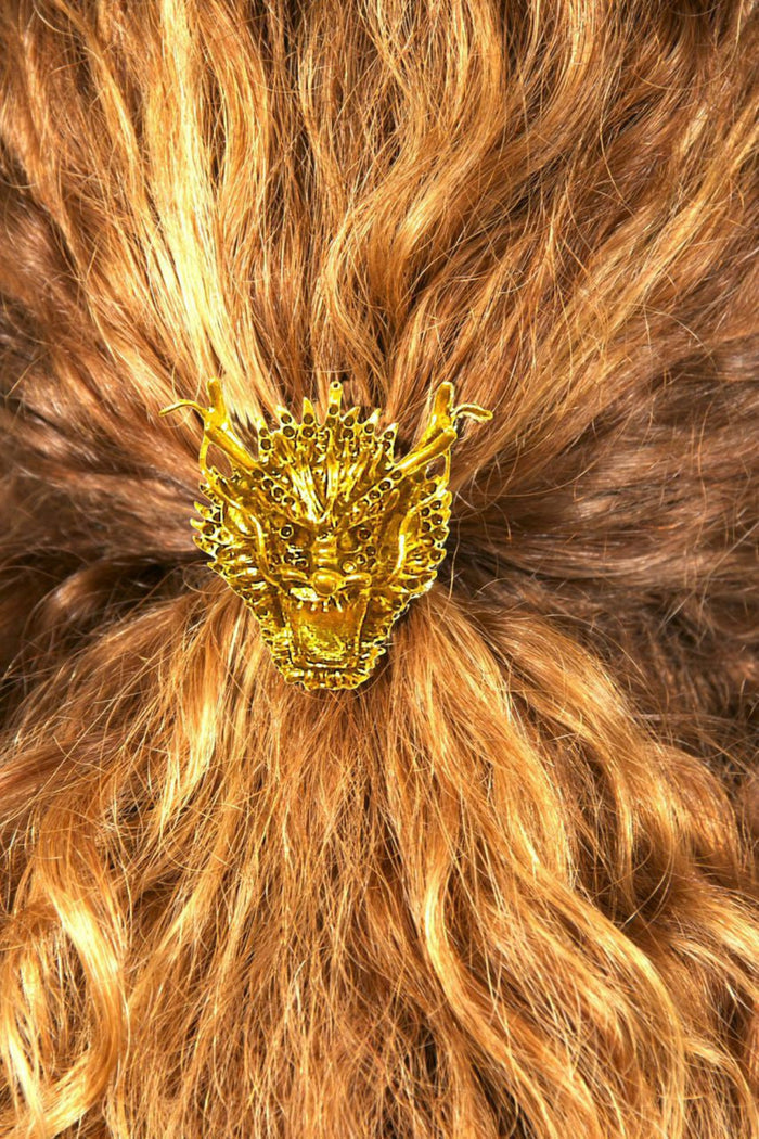 Gold dragon hair hook ponytail holder worn in curly red hair, back view