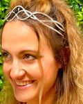 Model wearing silver wire braided crown with interwoven wire design and green gemstone centerpiece, front view.