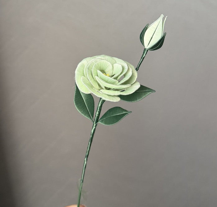 Handmade Eustoma Chanhua silk flower with green petals and bud, displayed on a stem against a neutral grey background, ideal for a DIY craft vase display.