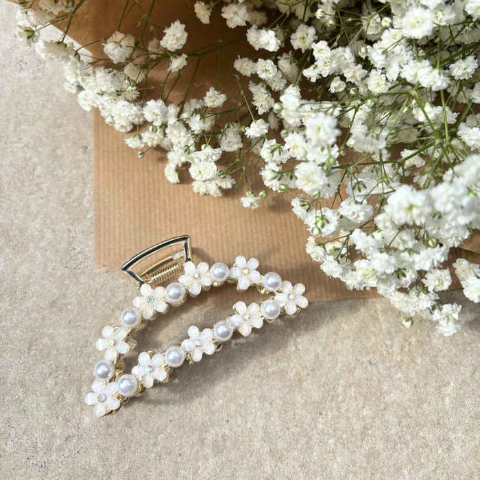 Coconut Lane claw clip with white flowers and pearls on a neutral background, accented by babys breath.