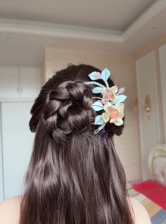 Pink - blue handmade Chanhua hairpin adorning a woman's hairstyle