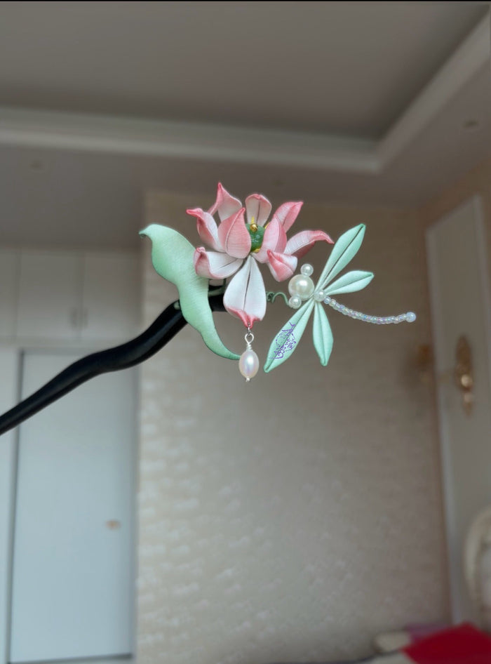 A handmade Chanhua lotus hairpin with pink petals, green leaves, a dragonfly, and pearls