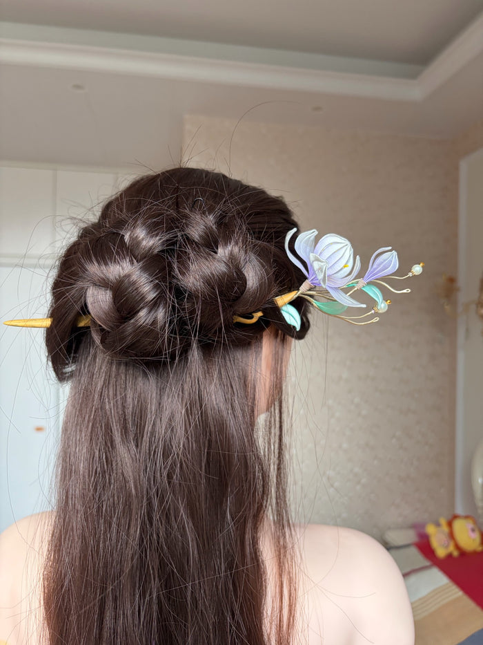 A handmade Chanhua magnolia hairpin with purple flowers and green leaves on a wooden stem.-3