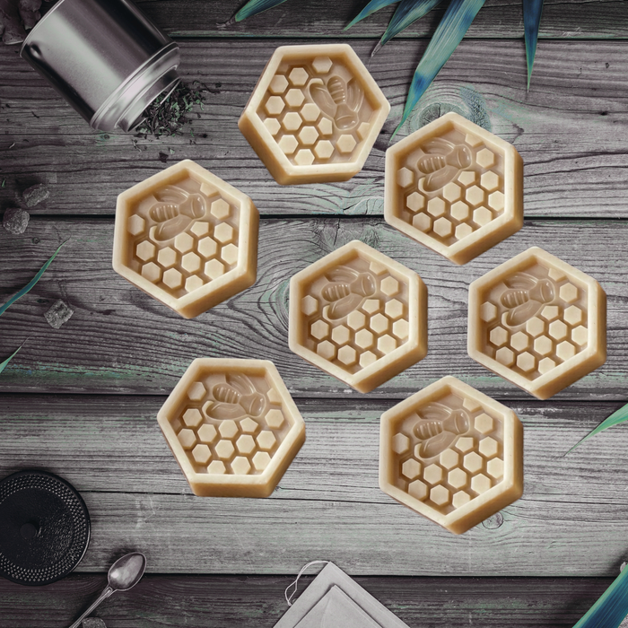 Hexagonal honeycomb and bee wax melts on a wooden surface