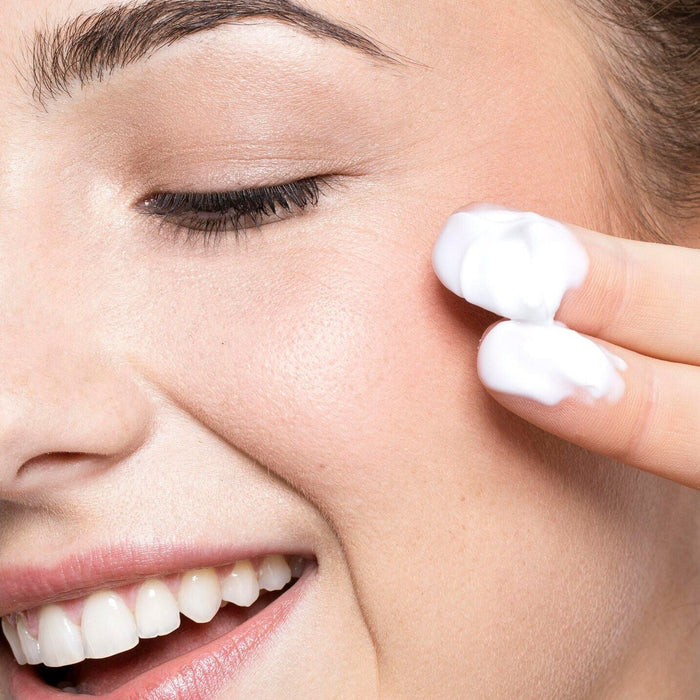 white woman brown hair two fingers applying best anti-aging face cream with peptide hyaluronic acid hydrating face cream dermal essentials medical grade skincare