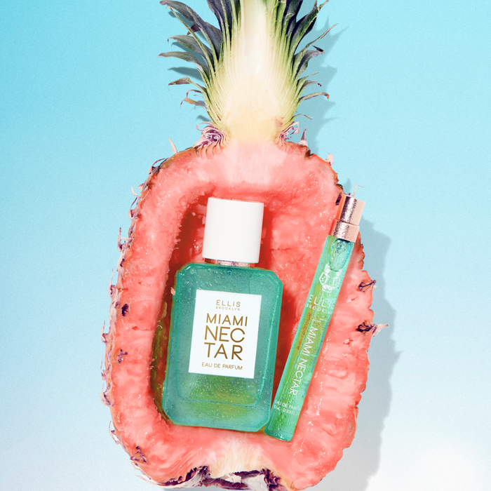 MIAMI NECTAR Eau de Parfum 50ml and MIAMI NECTAR Eau de Parfum 10ml site inside half a pink pineapple on blue background