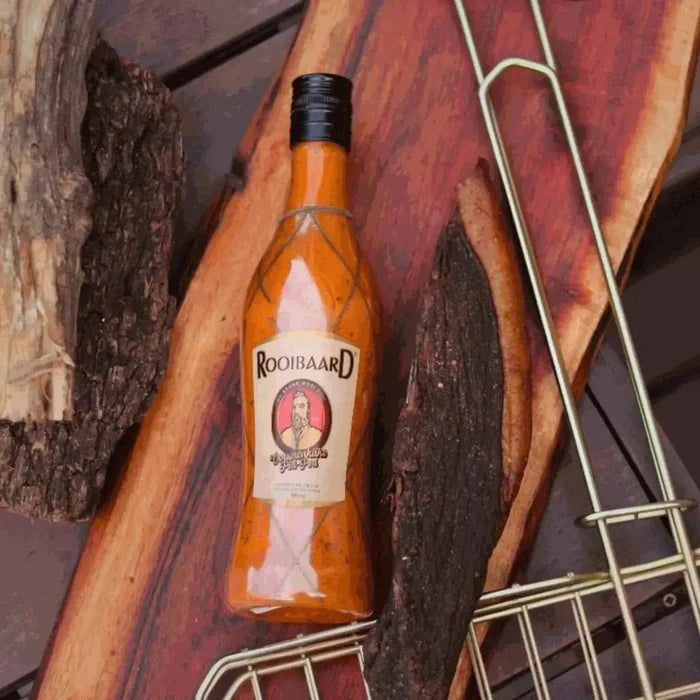 Rooibaard Original Peri Peri Sauce 550ml bottle on rustic wooden background.