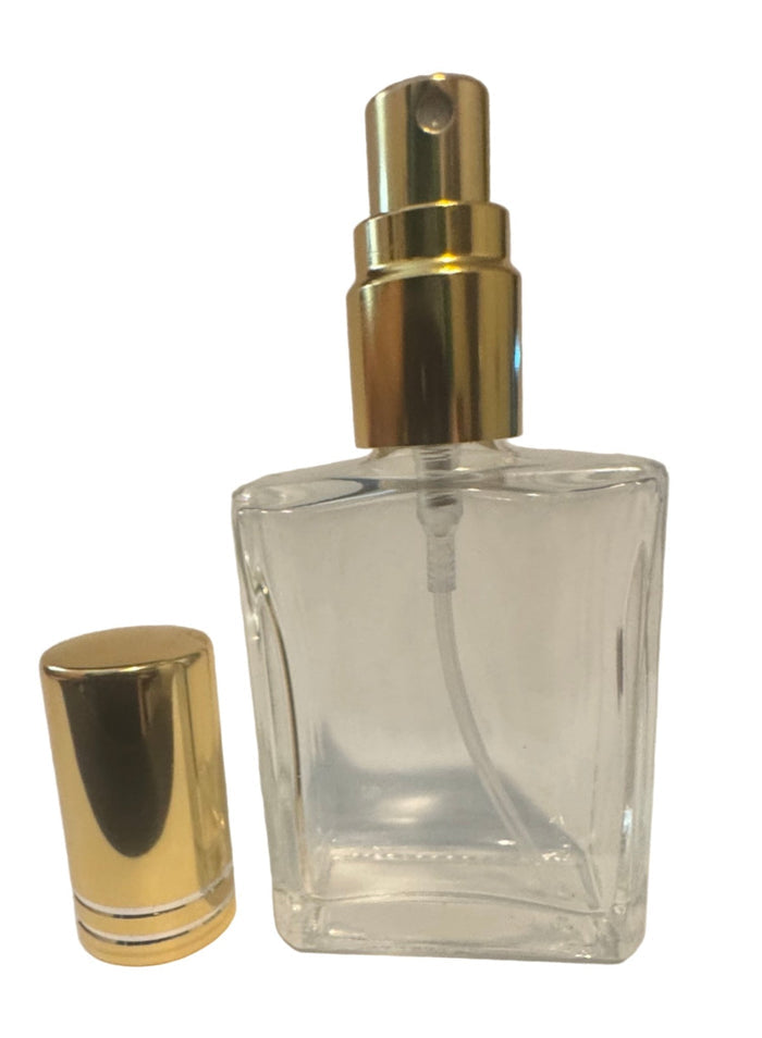 Clear glass bottle with gold cap on a white background. Travel size fragrance bottle.
