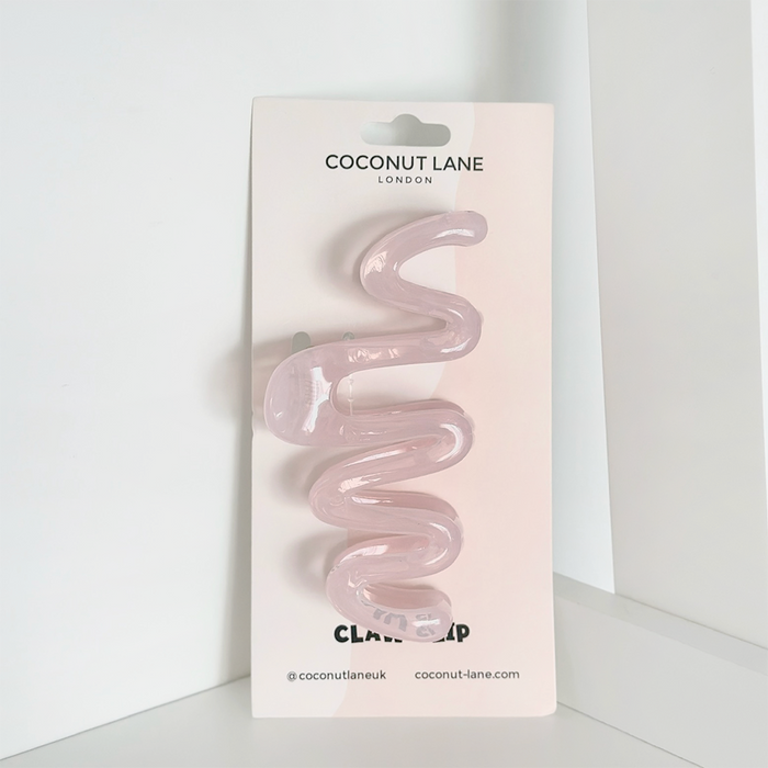 Pink squiggle-shaped claw clip on a Coconut Lane branded card, set against a white background.