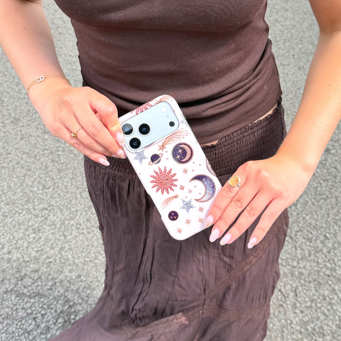 girl in brown outfit holding the tough magsafe after dark celestial phone case