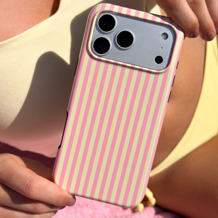 Tough Phone case with pink and yellow striped design held by a person