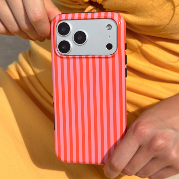 Person holding a phone with a orange and pink striped case against a yellow dress
