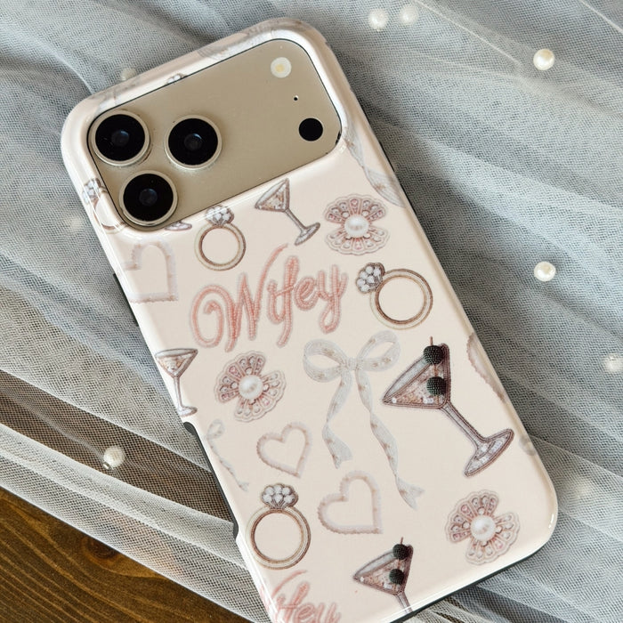 Light pink Phone case with 'Wifey' text and wedding-themed designs, laid on top of a sheer veil