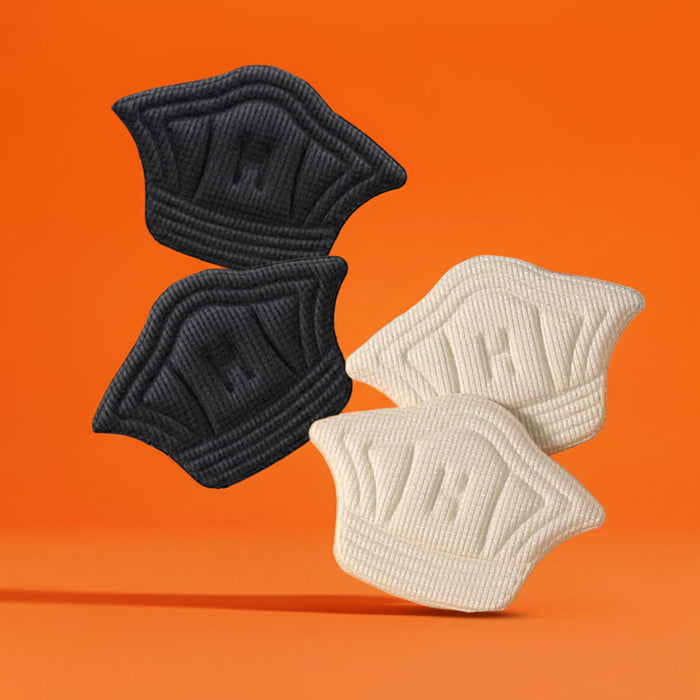 Beige and black fabric heel cushions floating against an orange backdrop.