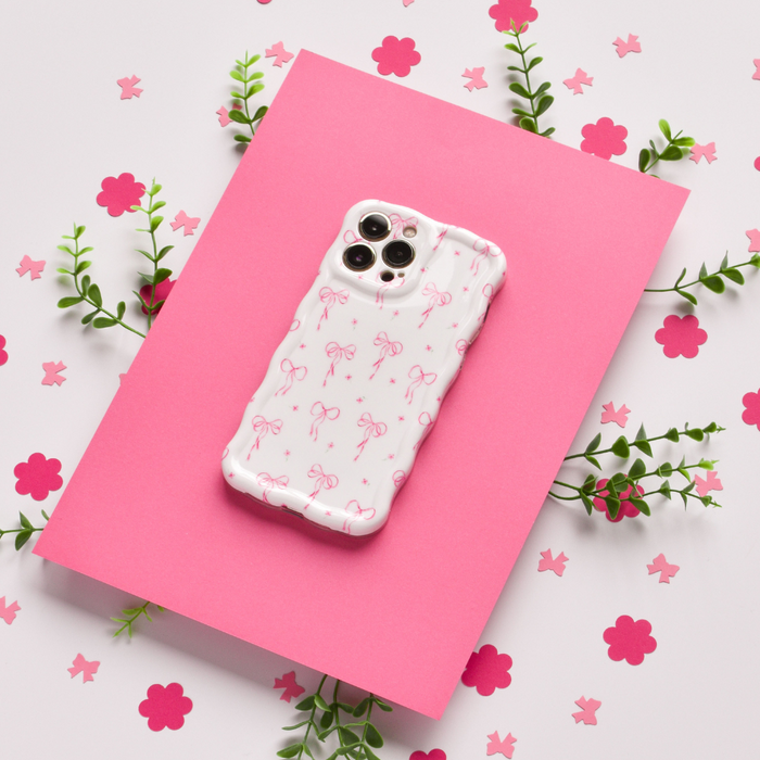 Pink Coconut Lane wavy phone case with small bows, green leaves, and pink flowers.