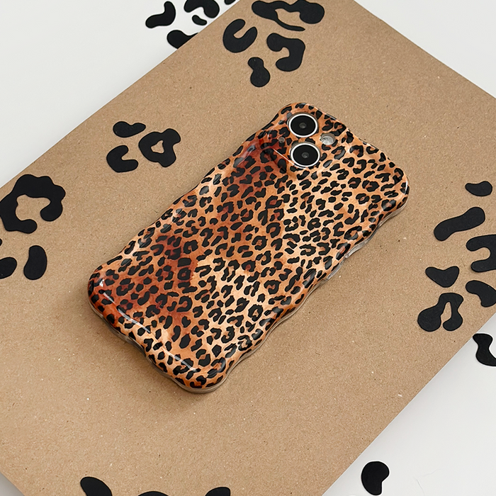 Leopard print wavy phone case by Coconut Lane on a brown surface with similar leopard pattern.