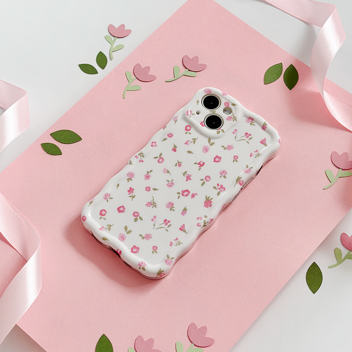 Wavy phone case with pink watercolor floral pattern on a soft pink background.