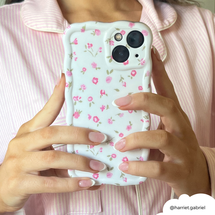Coconut Lane Wavy Phone Case in pink with watercolor flower pattern, held by a person in pink pajamas with French-manicured nails.