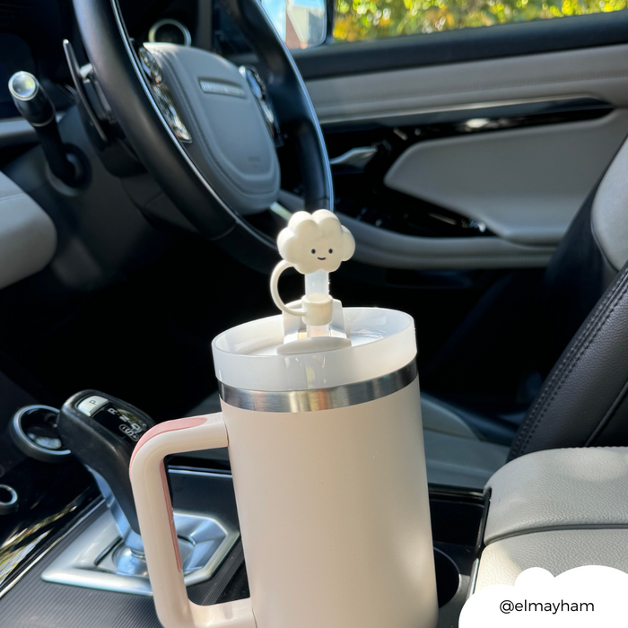 White Cloud Straw Cover from Coconut Lane on a travel mug in a car cup holder by the steering wheel.
