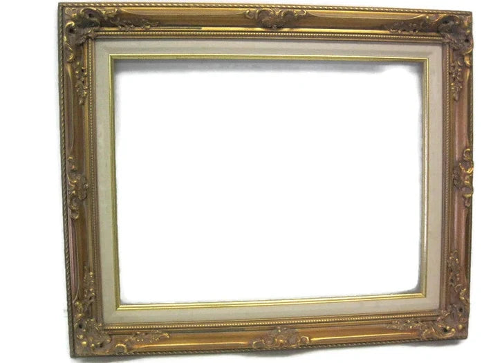 An ornate wooden picture frame with gold leaf detailing and a linen liner, designed for showcasing photographs or artwork.